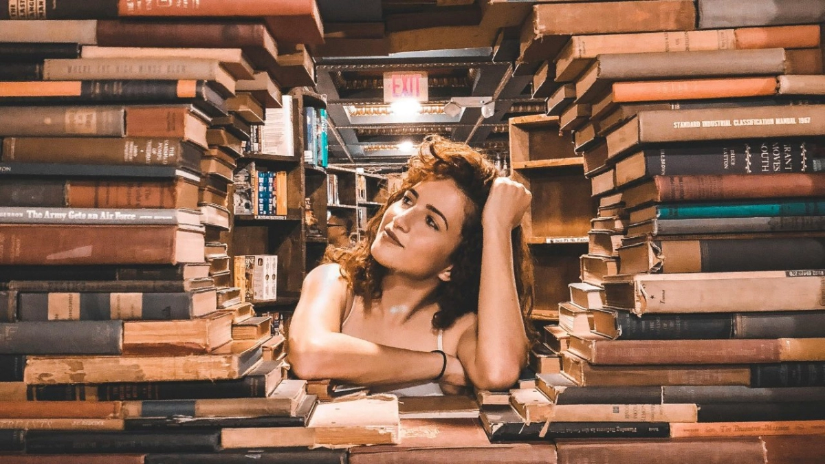 Kobieta na tle książek - fotografia ilustracyjna